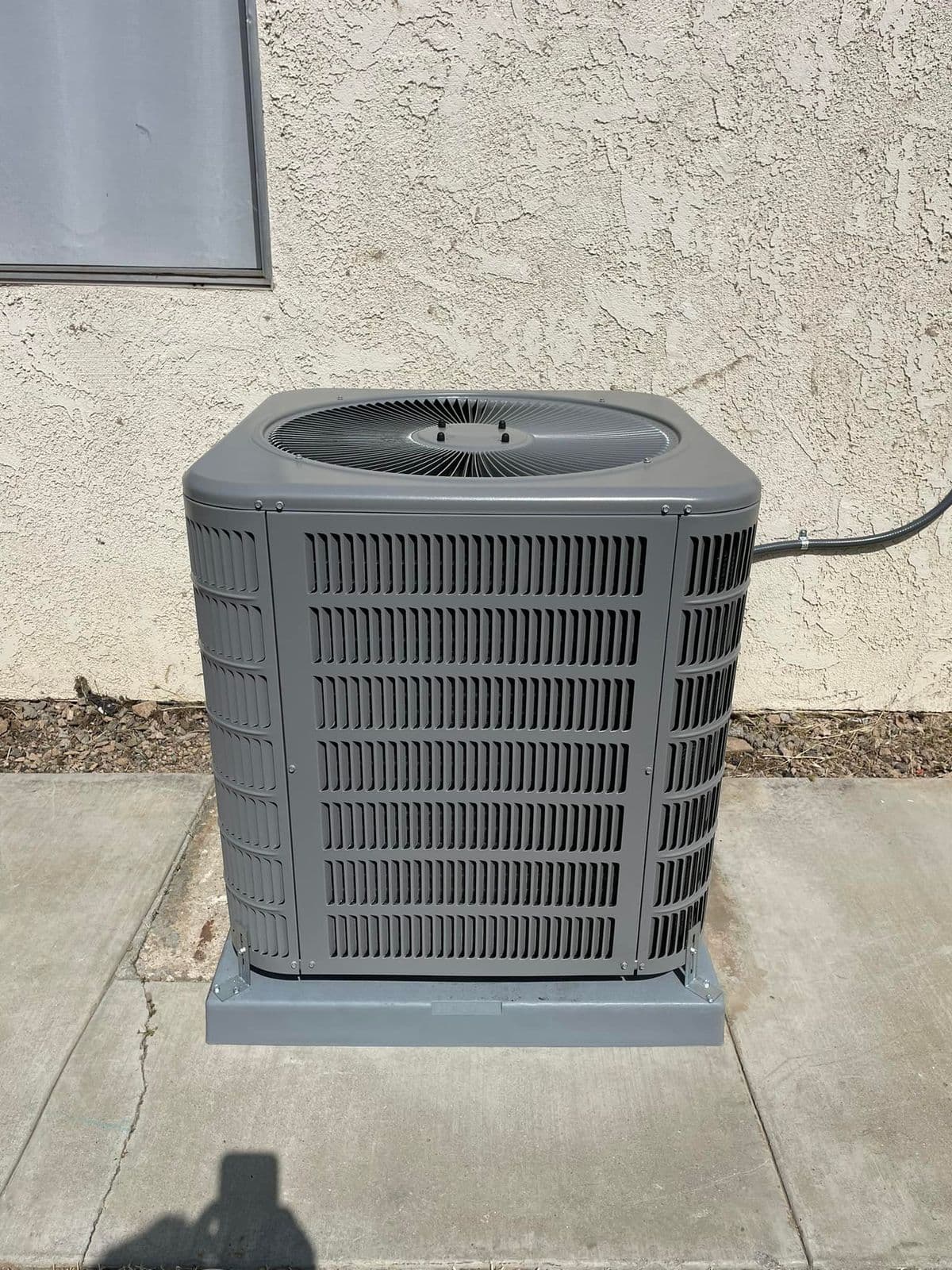 New air conditioner installed on a concrete pad