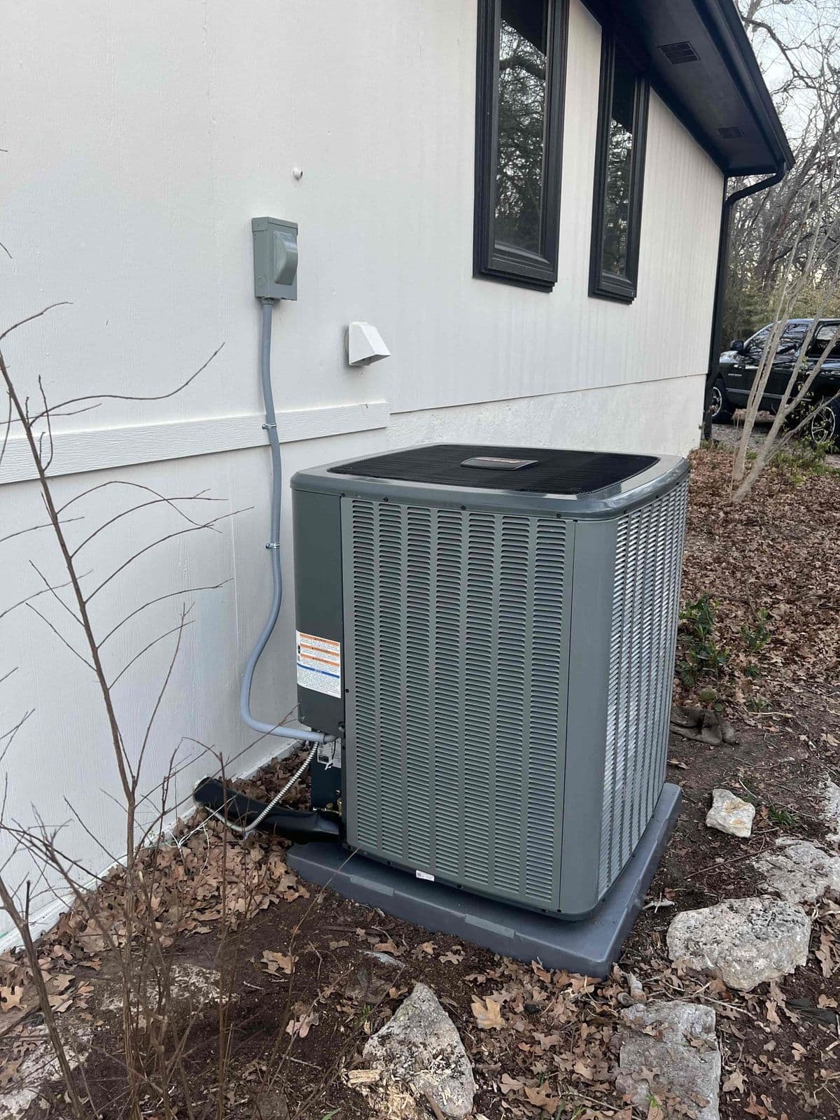 New outdoor unit beside a light colored house