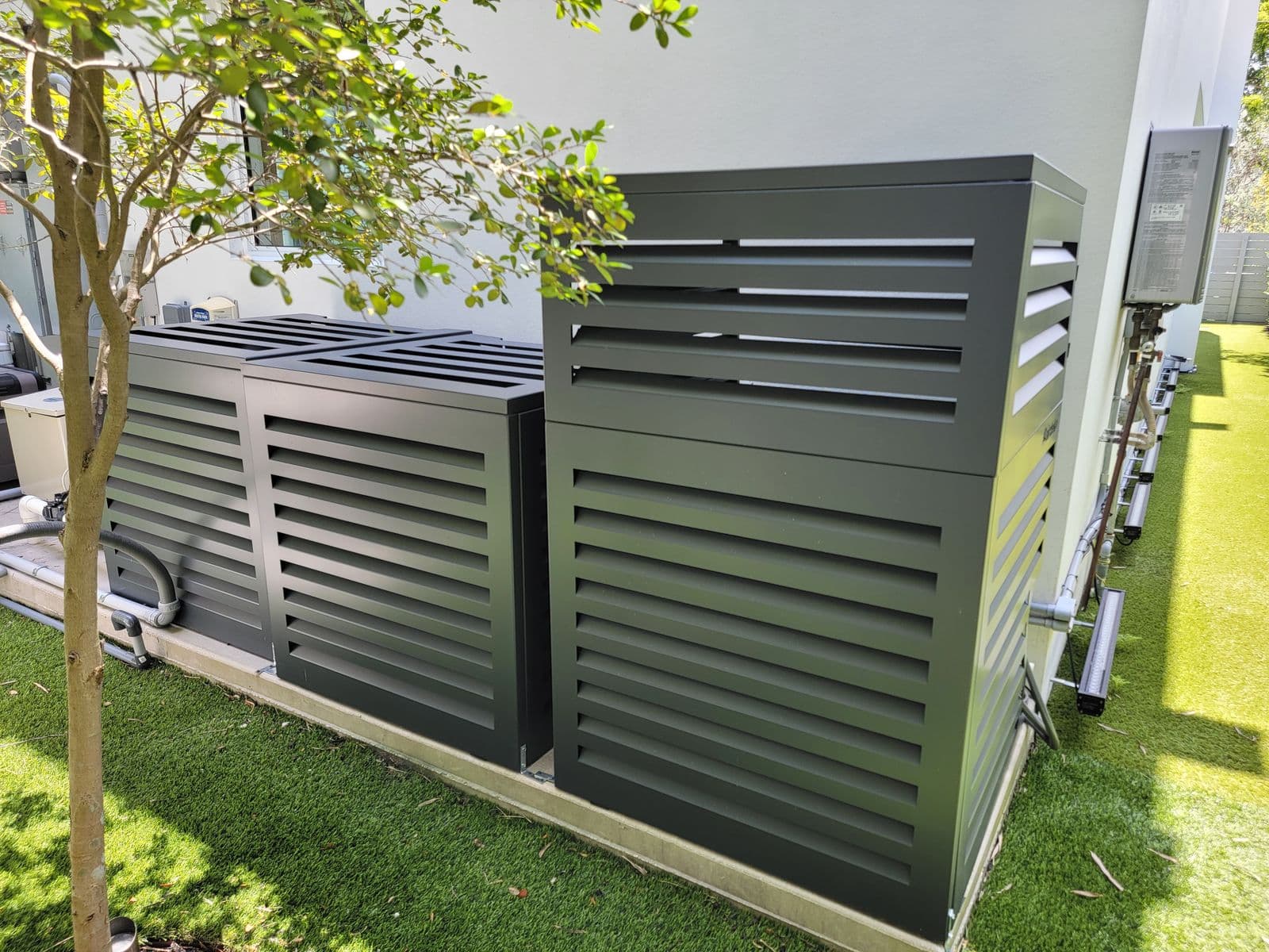 Two outdoor units enclosed in a louvered screen