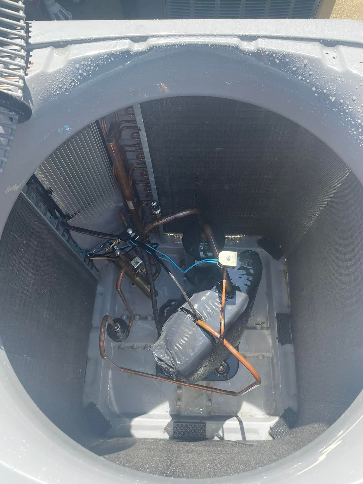Condenser fan and motor viewed from above during a repair
