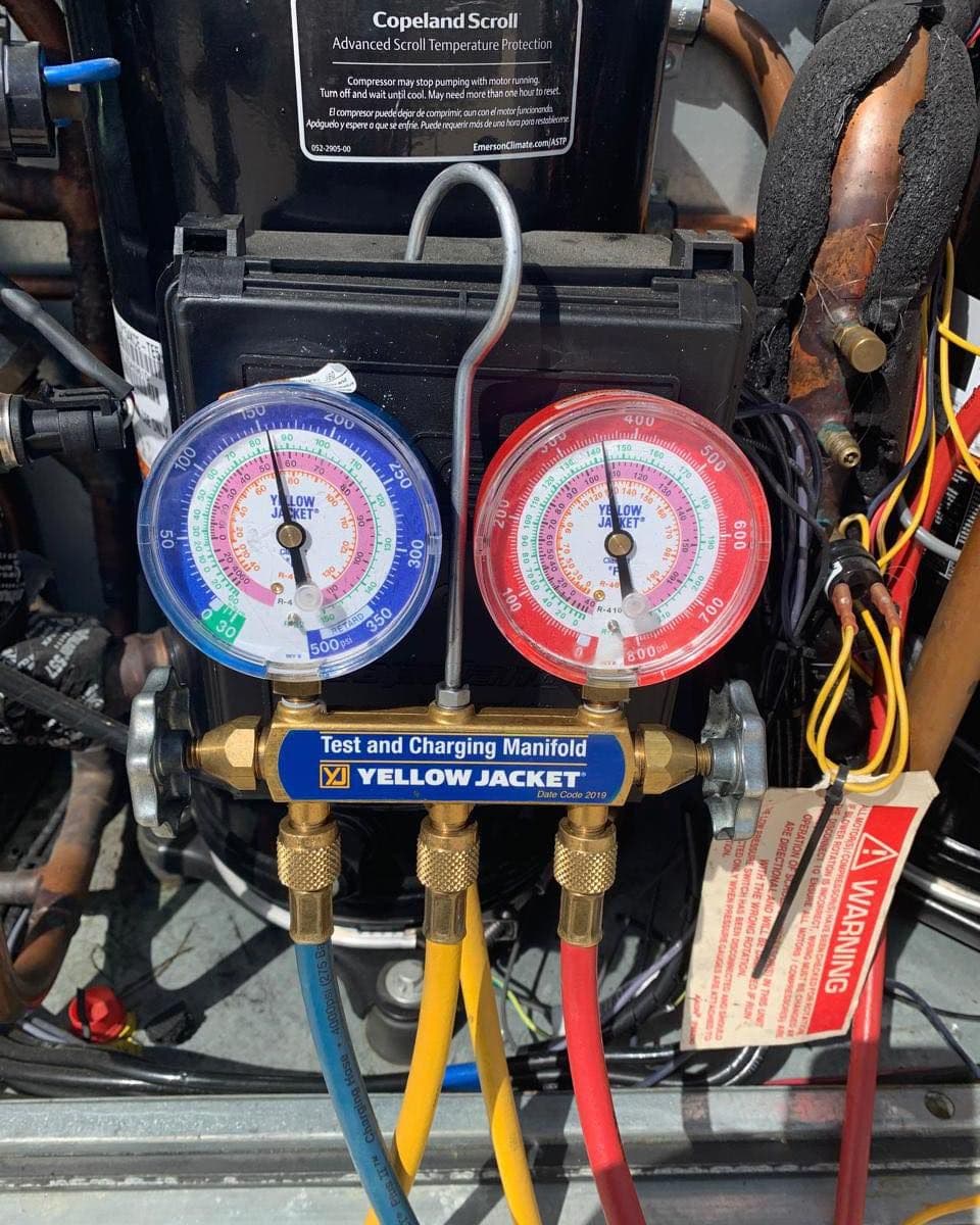 Refrigerant gauge set connected to an outdoor unit during diagnosis
