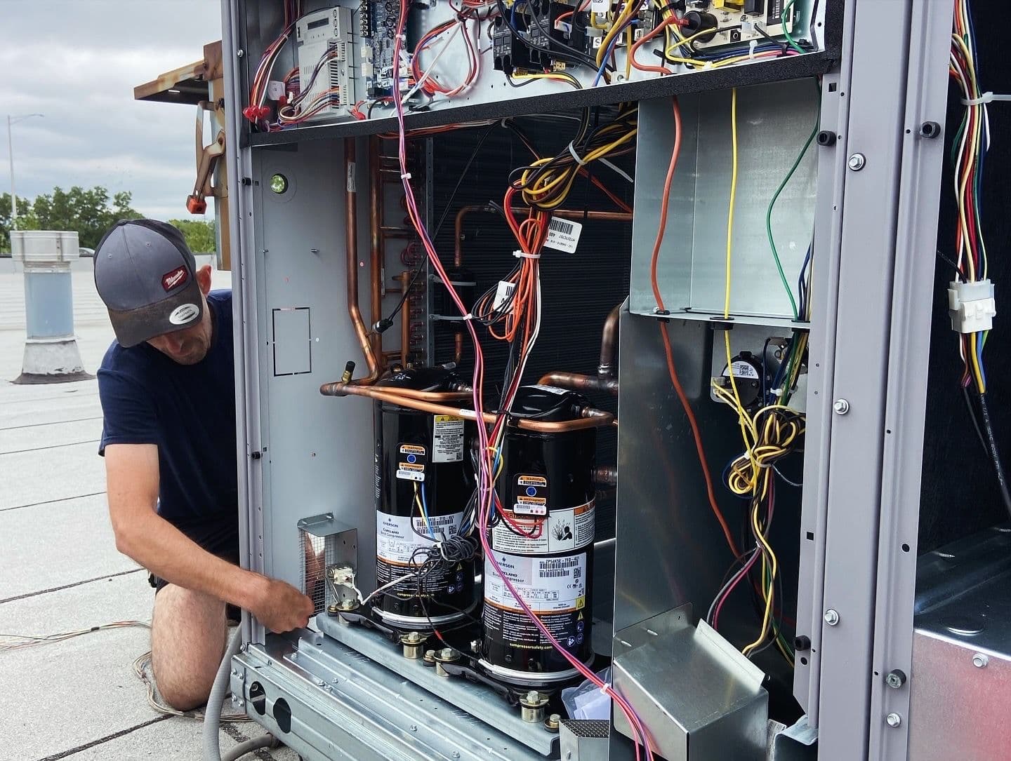 Technician working inside a rooftop air conditioning unit