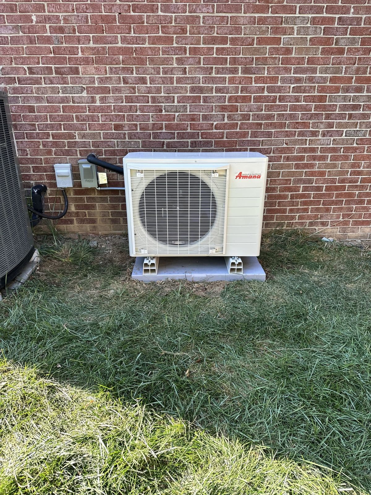 Mini split outdoor unit against a brick wall