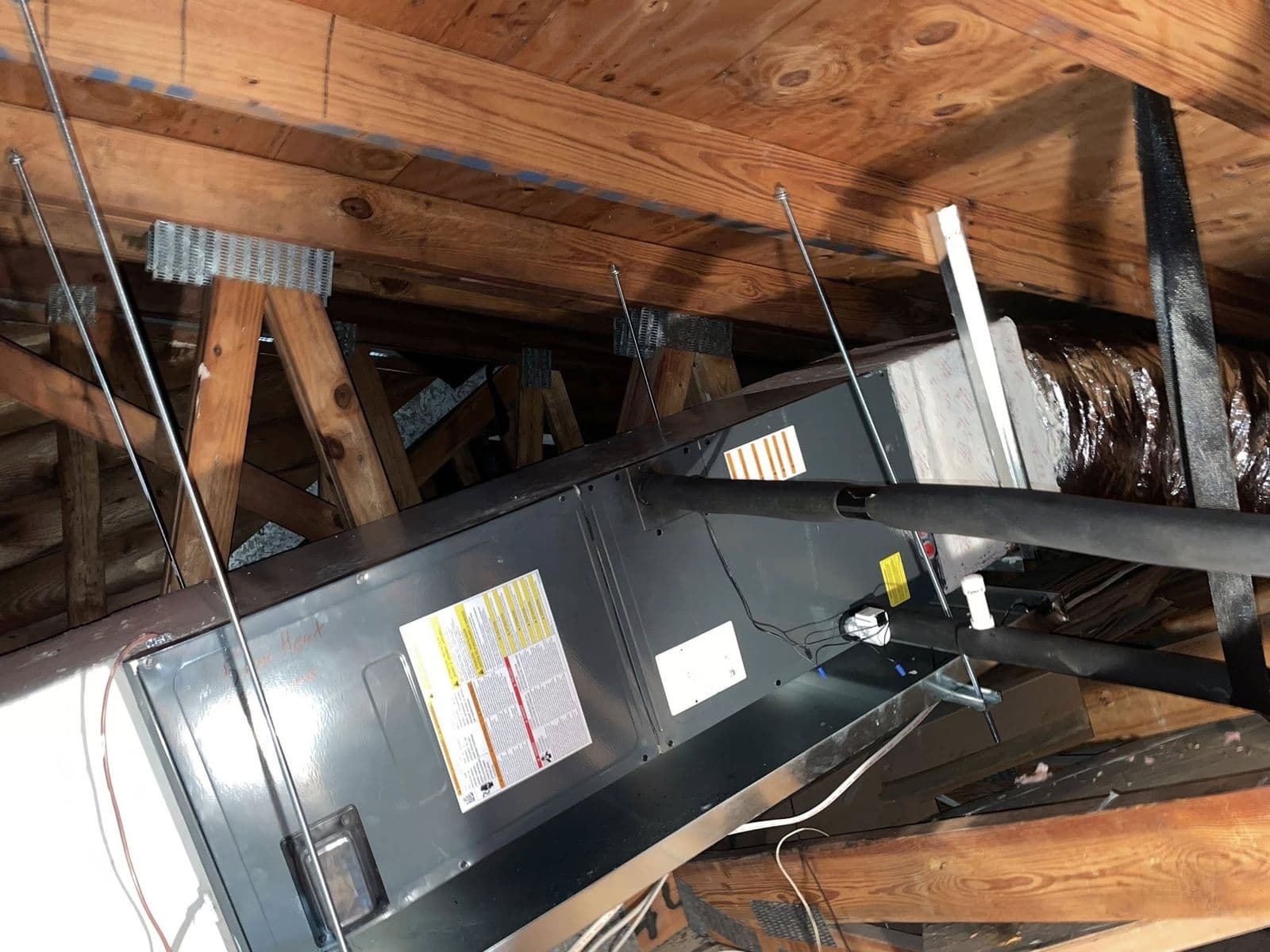 Furnace unit in an attic with ducts and framing