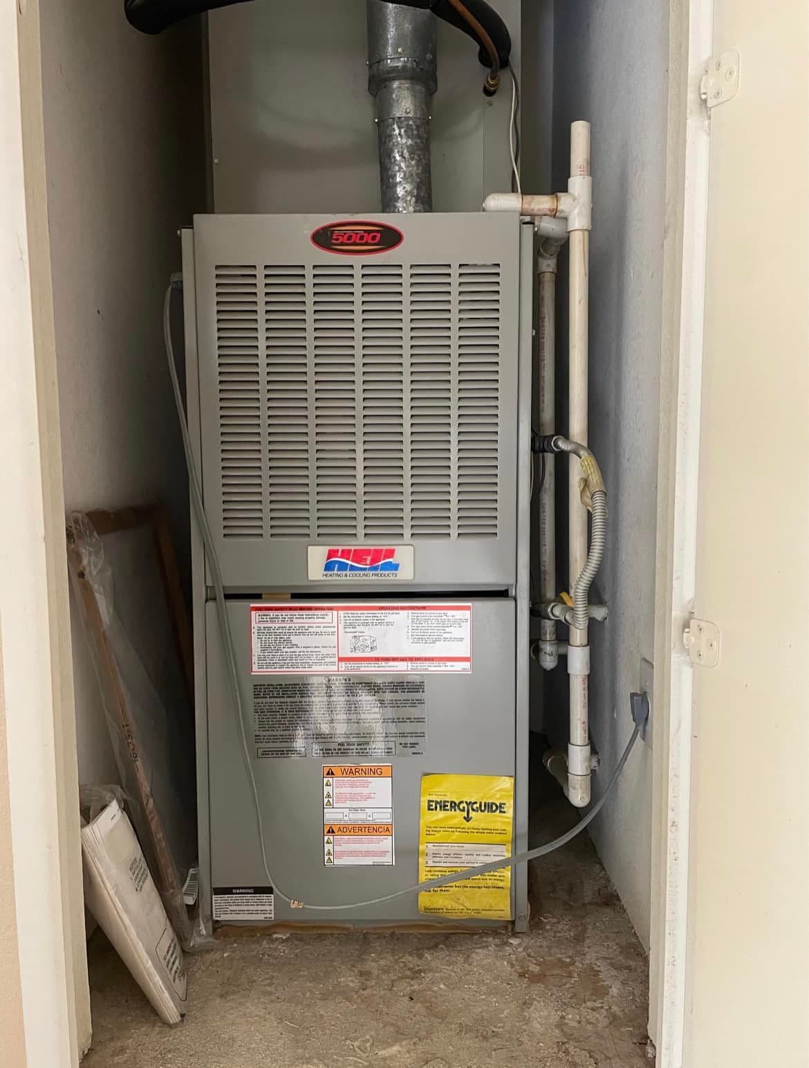 Gas furnace in a closet with a white drain line