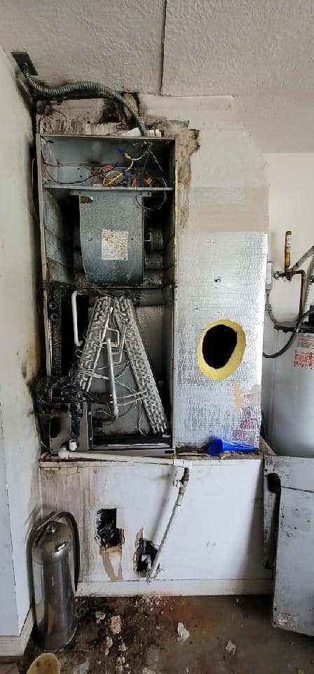 Old furnace cabinet with burn marks and rust