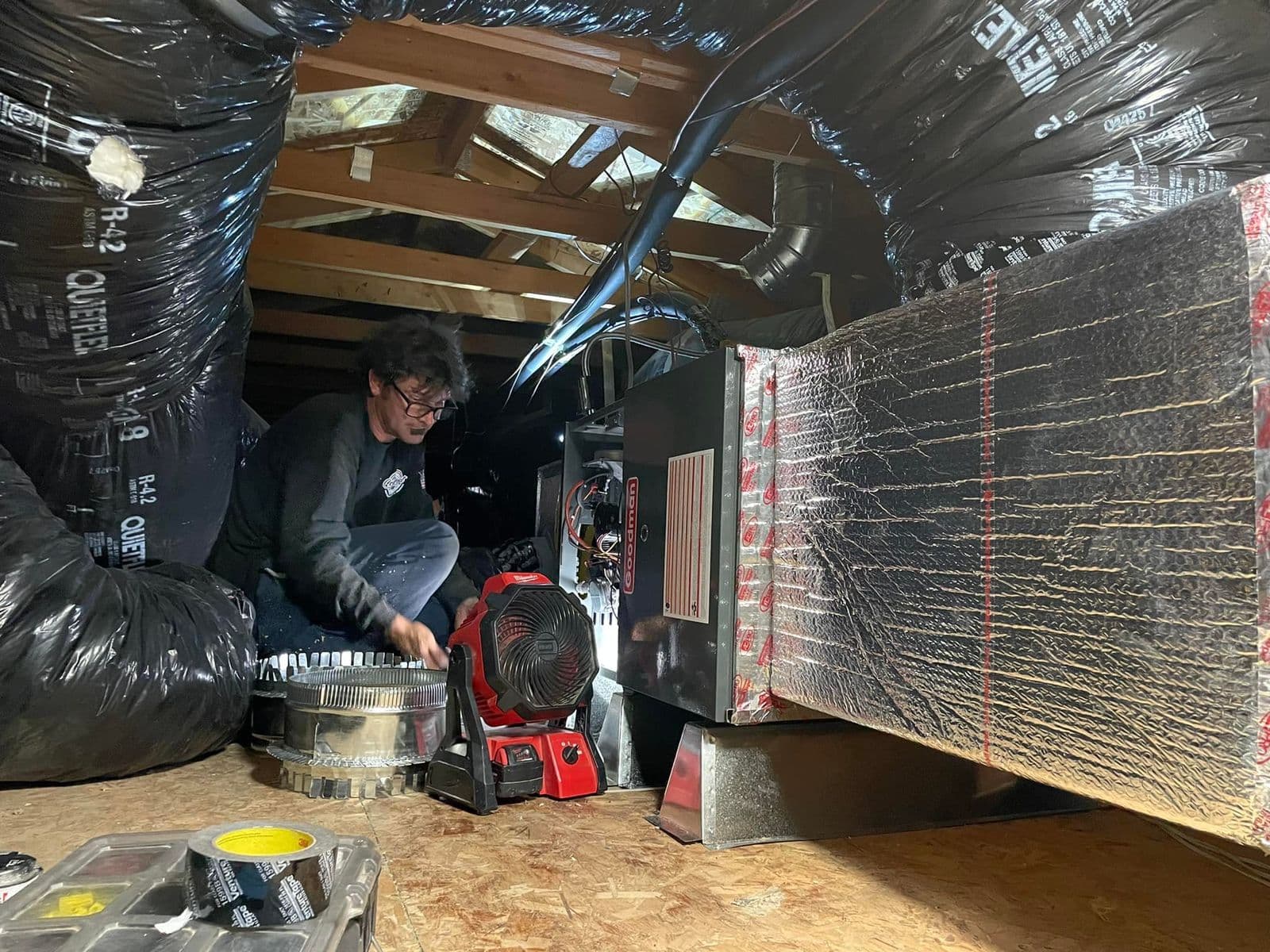 Technician working on a furnace in an attic