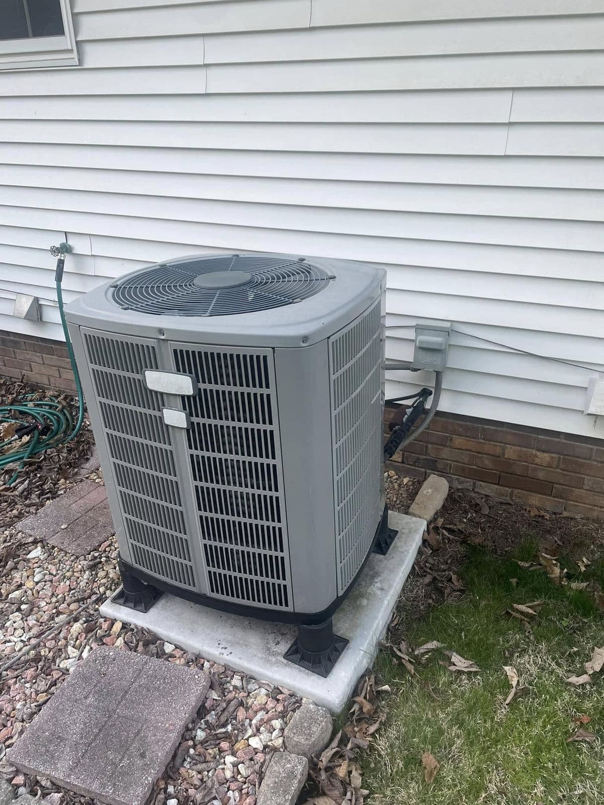 Heat pump condenser beside siding