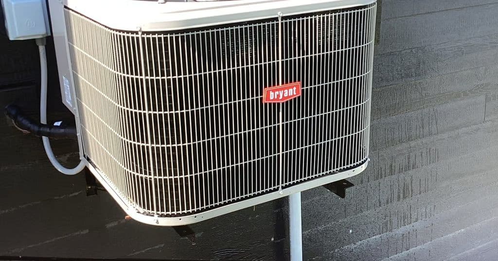 Bryant condenser beside a house