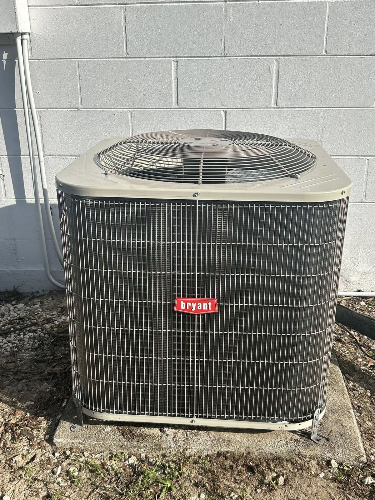 Bryant condenser beside a stucco wall