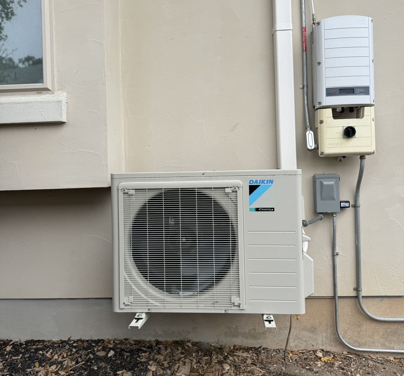 Daikin mini split outdoor unit on a stucco wall