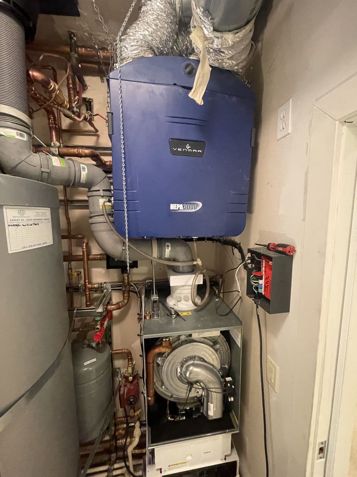 Utility closet with copper piping and heating equipment