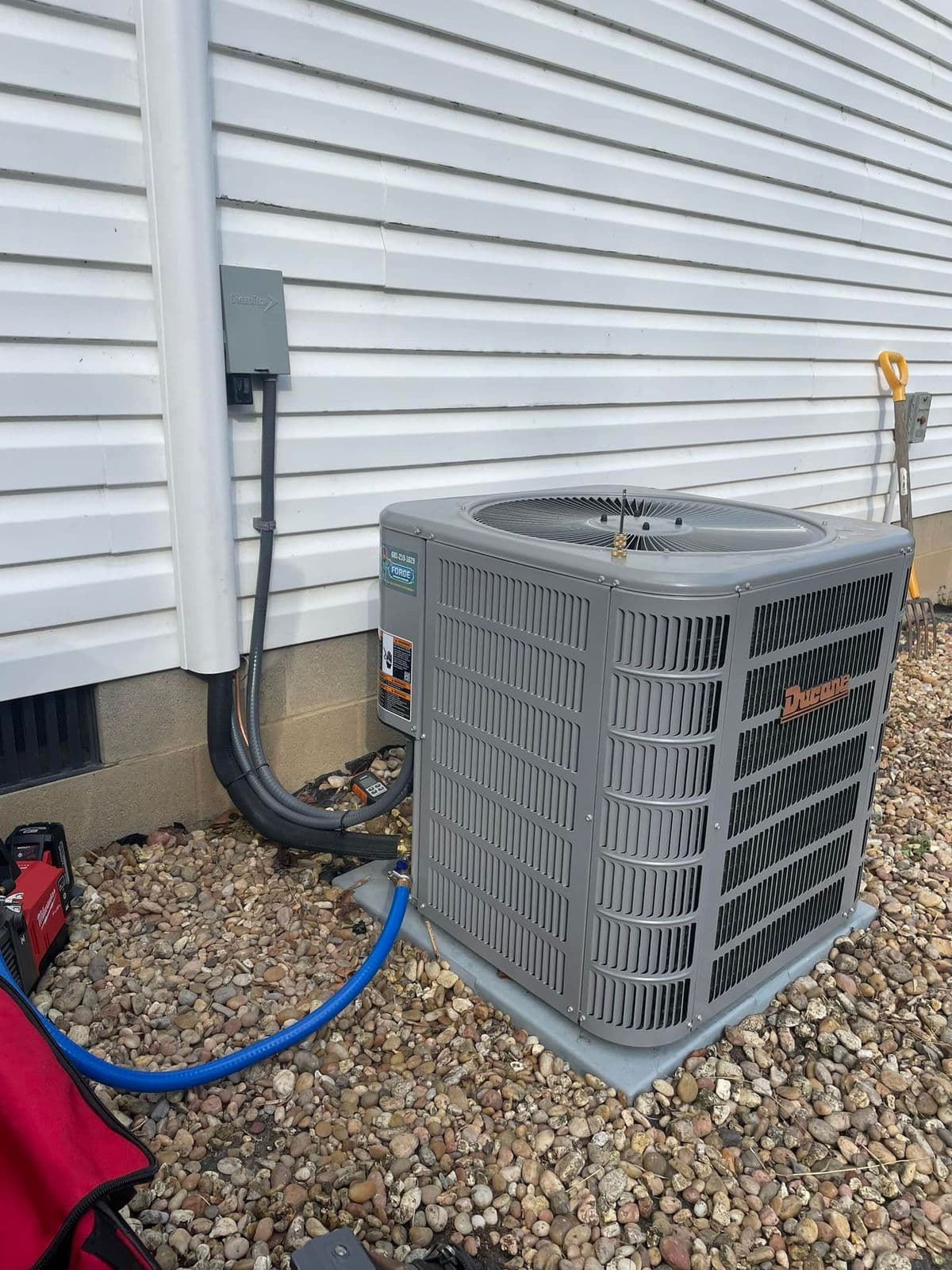 Outdoor unit being serviced with a hose attached